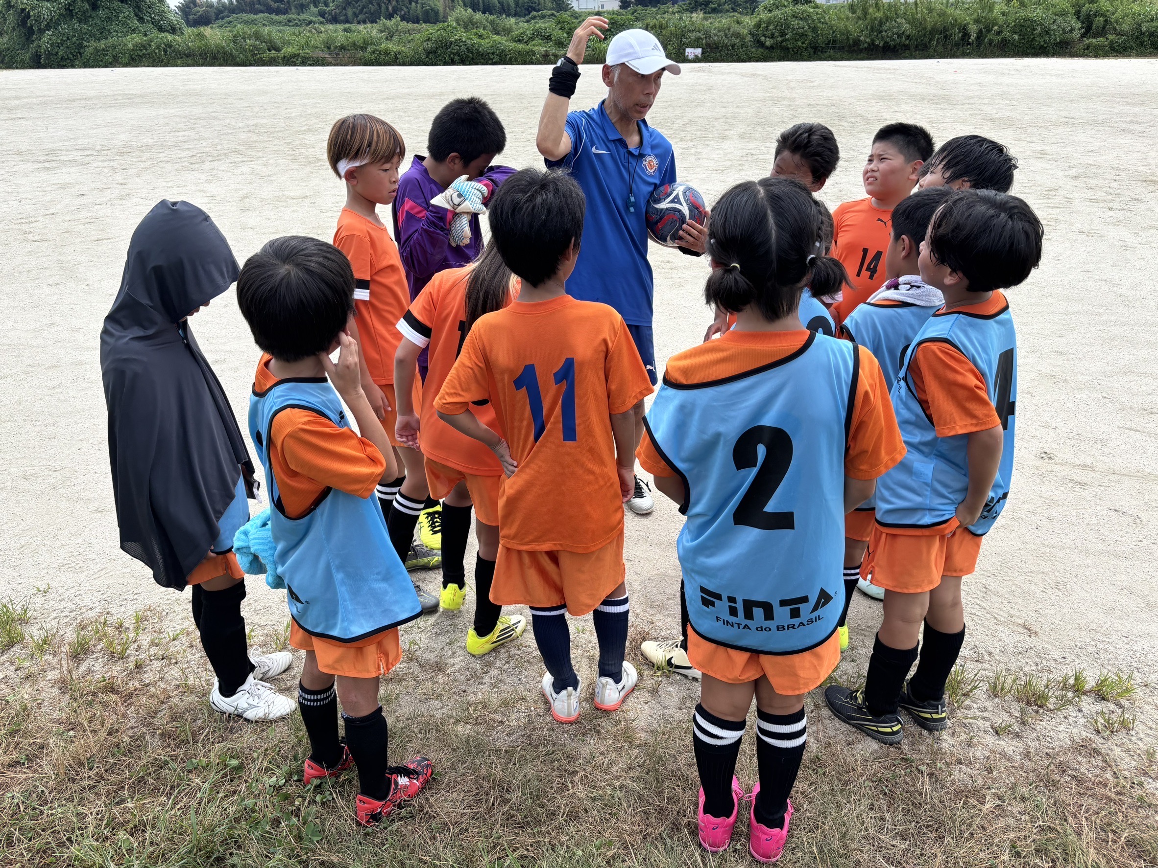 コーチとジュニア選手たちが練習前に集まる様子